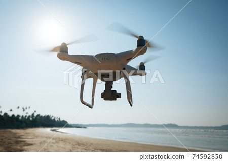 Drone flying in the air under at seaside Drone flying in the air under at seaside 74592850