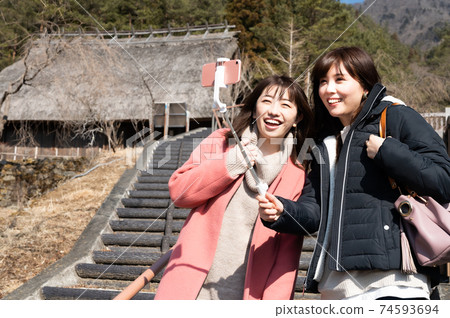 Two women taking a commemorative photo with Saiko Iyashiba in the background Two women taking a commemorative photo with Saiko Iyashiba in the background 74593694