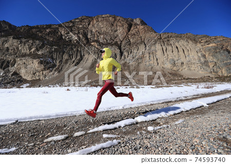 Woman trail runner cross country running in winter nature Woman trail runner cross country running in winter nature 74593740