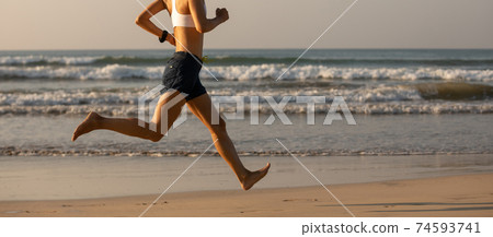 Young fitness woman running at sunrise beach Young fitness woman running at sunrise beach 74593741