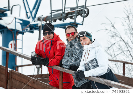 group of skiers friends on the mountain are resting and drinking coffee from a thermos on the background of the ski lift group of skiers friends on the mountain are resting and drinking coffee from a thermos on the background of the ski lift 74593861
