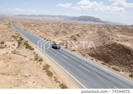 Aerial view of suv runnning on  trail in desert 74594078