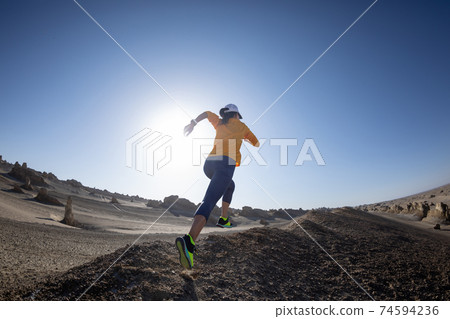 Fitness woman trail runner cross country running on sand desert Fitness woman trail runner cross country running on sand desert 74594236