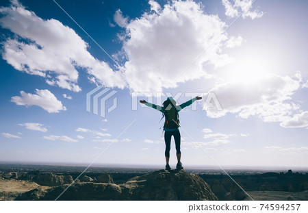 Successful backpacker hiking on sand desert 74594257