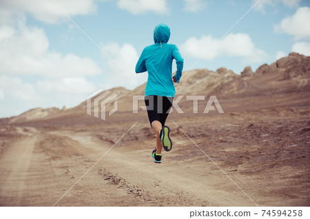 Fitness woman trail runner cross country running on sand desert 74594258