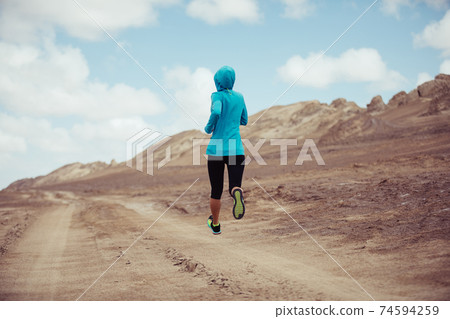 Fitness woman trail runner cross country running on sand desert 74594259
