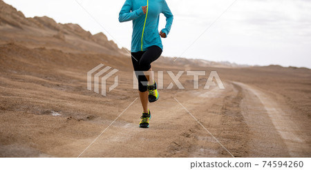 Fitness woman trail runner cross country running on sand desert Fitness woman trail runner cross country running on sand desert 74594260