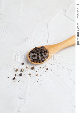 Black pepper and wooden spoon 74594501