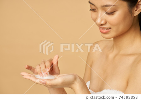 Close up portrait of lovely young woman ready to apply gentle foam facial cleanser Close up portrait of lovely young woman ready to apply gentle foam facial cleanser 74595858