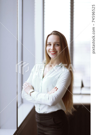 business woman standing near the window in the corridor of the office. 74596525