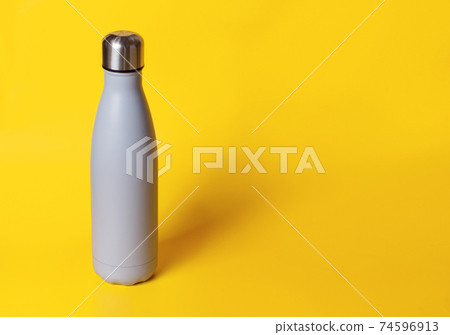 Grey reusable steel bottle on yellow background 74596913
