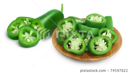 sliced jalapeno pepper in wooden bowl isolated on white background. Green chili pepper with clipping path and full depth of field. 74597822