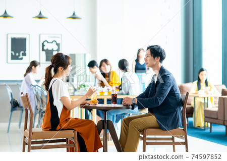 Young men and women talking in a cafe 74597852