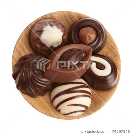 Chocolate candy in wooden bowl isolated on white background with clipping path and full depth of field. Top view. Flat lay Chocolate candy in wooden bowl isolated on white background with clipping path and full depth of field. Top view. Flat lay 74597946