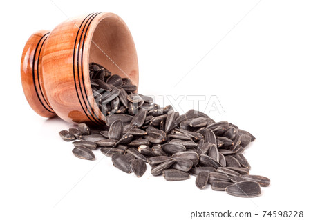 sunflower seeds spill out of wooden barrels on white background sunflower seeds spill out of wooden barrels on white background 74598228