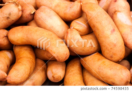 many sausages in natural casing as a background 74598435