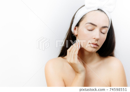 woman washing face with sponge woman washing face with sponge 74598551