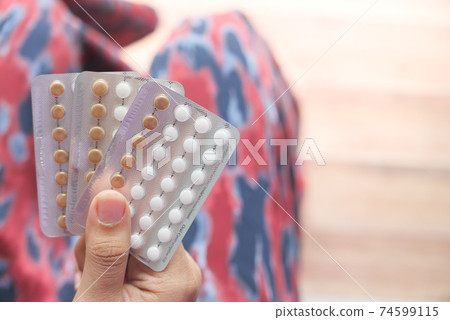 women hand golding birth control pills close up women hand golding birth control pills close up 74599115