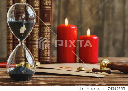 Wooden desk with vintage sandglass and old letter Wooden desk with vintage sandglass and old letter 74599265
