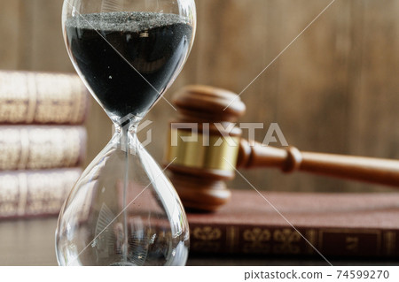 Court concept. Hourglass and judge gavel on table Court concept. Hourglass and judge gavel on table 74599270