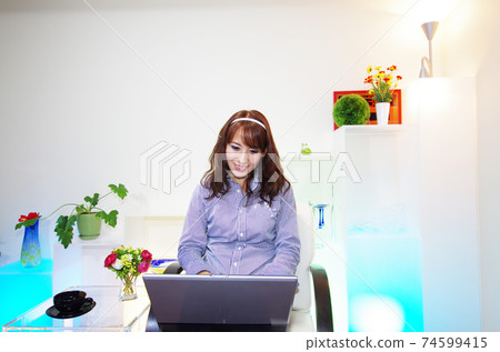 A woman enjoying a laptop computer 74599415