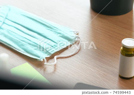 Medical protective mask on office table. Coronavirus spread prevention concept 74599443