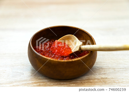 Fresh red caviar in bamboo bowl with wooden spoon on rustic bleached white wood table background Fresh red caviar in bamboo bowl with wooden spoon on rustic bleached white wood table background 74600239