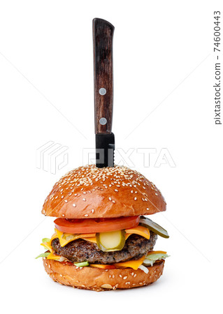 Cooked burger with pinned knife isolated on white Cooked burger with pinned knife isolated on white 74600443