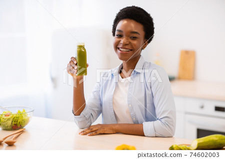 Black Woman Holding Smoothie Bottle Posing In Modern Kitchen Indoor Black Woman Holding Smoothie Bottle Posing In Modern Kitchen Indoor 74602003