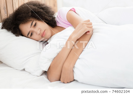 Sad, depressed young african american lady in bed without sleepy feeling desperate Sad, depressed young african american lady in bed without sleepy feeling desperate 74602104