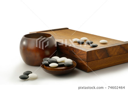 black and white stones of baduk game on wooden board isolated on white black and white stones of baduk game on wooden board isolated on white 74602464