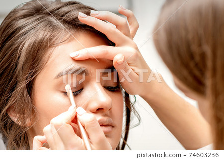 Makeup artist applies eye shadow 74603236