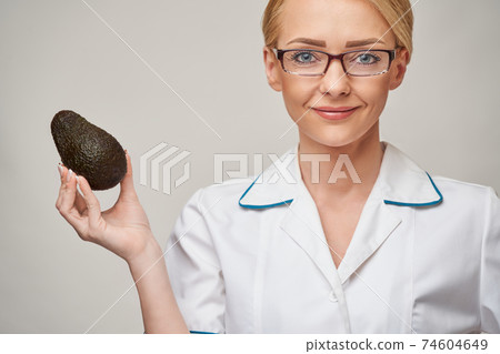 nutritionist doctor healthy lifestyle concept - holding organic avocado fruit nutritionist doctor healthy lifestyle concept - holding organic avocado fruit 74604649