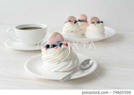 Still life with Pavlova meringue cake with fresh berries on white background. Still life with Pavlova meringue cake with fresh berries on white background. 74605509