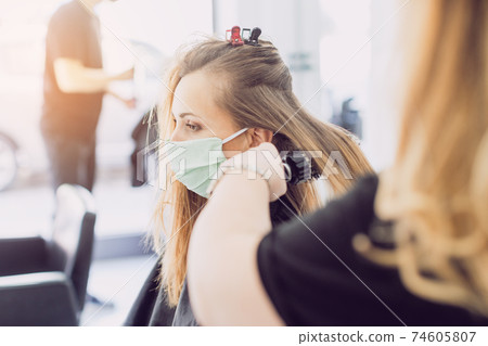 Woman visiting the hairdresser wearing face mask Woman visiting the hairdresser wearing face mask 74605807
