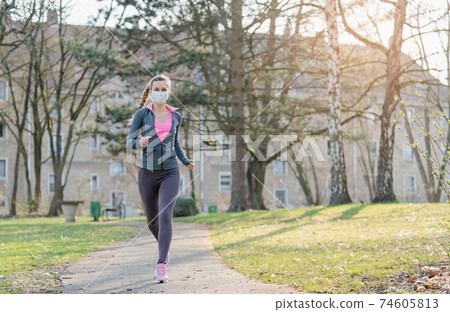 Woman jogging down a path boosting her immune system for covid-19 74605813