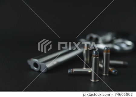357 Caliber hollow point bullets near revolver pistol gun on black background 74605862