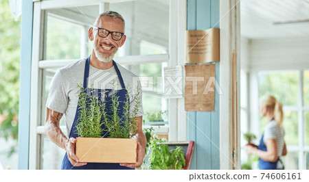 Middle aged caucasian man holding pot with rosemary 74606161