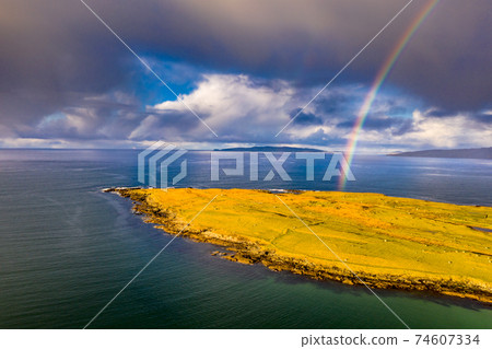 Aerial view of an rainbow above the Atlantic Ocean and Inishkeel by Portnoo in Donegal - Ireland Aerial view of an rainbow above the Atlantic Ocean and Inishkeel by Portnoo in Donegal - Ireland 74607334