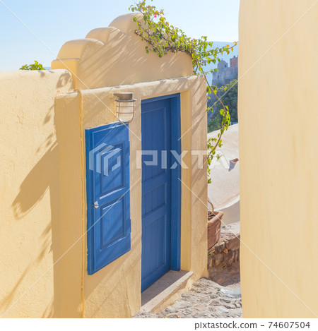 Greece, Santorini. Old blue door and window in the narrow street. Greece, Santorini. Old blue door and window in the narrow street. 74607504