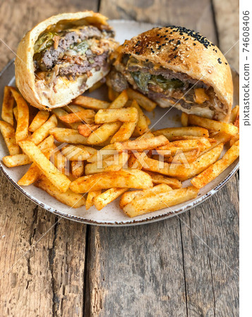 halved hamburger and french fries on plate halved hamburger and french fries on plate 74608406