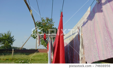 Multi-colored linen is dried on the street of the village. 74608956
