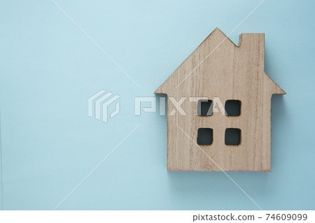 House insurance and mortgage, buying or rent concept. Wooden model house over blue background, top view with copy space 74609099