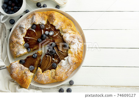 Galette or pie, tart with pears and cinnamon filling. Top view, white wooden background. 74609127