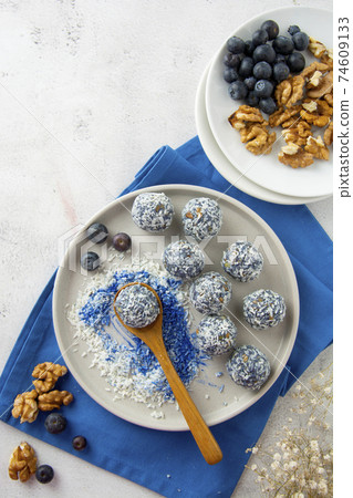 Energy balls or bites made with blue spirulina powder, nuts, dried fruits and coconut flakes. Healthy dessert 74609133