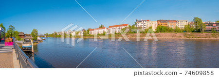Panoramic view over beach cafes, restaurants, and other landmarks as multistory living houses at the historical downtown and Elbe river at Spring, Magdeburg, Germany. 74609858