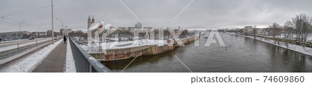 Panoramic view over Magdeburg historical downtown in Winter with icy trees and snow during foggy day and dramatic sky, Germany. 74609860