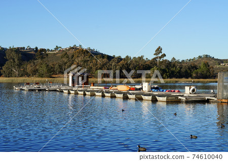 Wood pier with pedal boat and small boat.  74610040