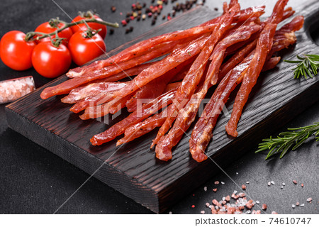 Tasty hearty meat salted and dried with pieces of spices and herbs 74610747