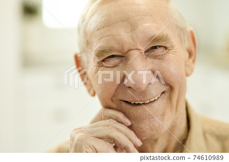 Outgoing grandpa looking optimistic while posing for camera 74610989